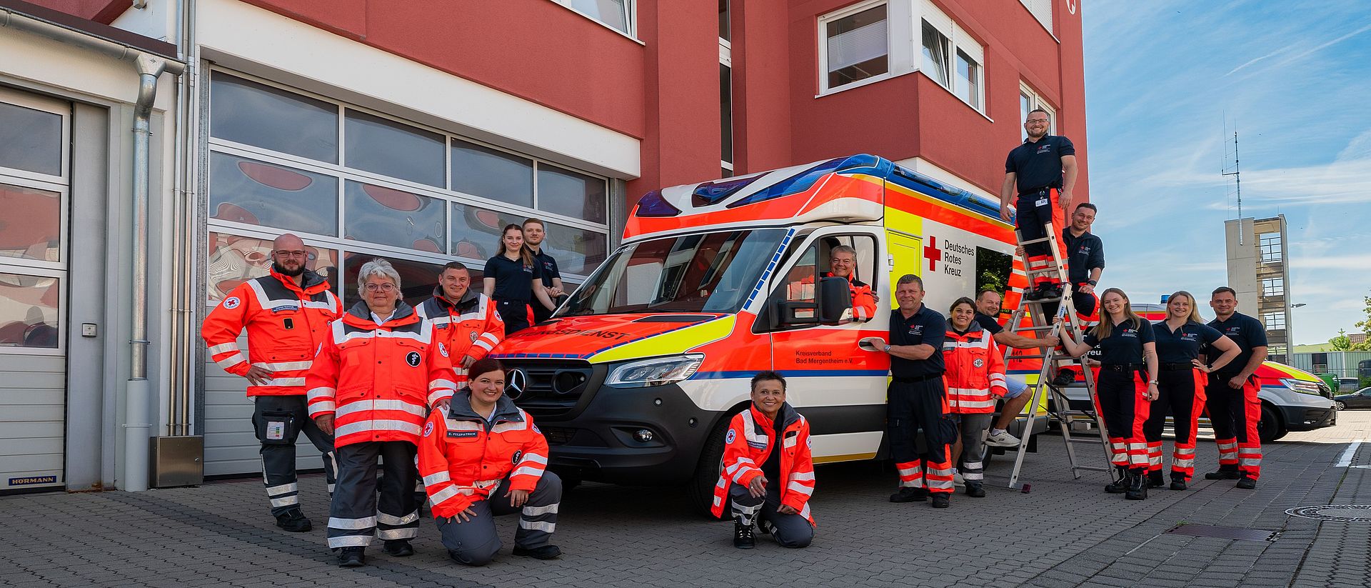 Es sind Mitarbeiter des DRK in Ihrer Dienstkleidung zu sehen